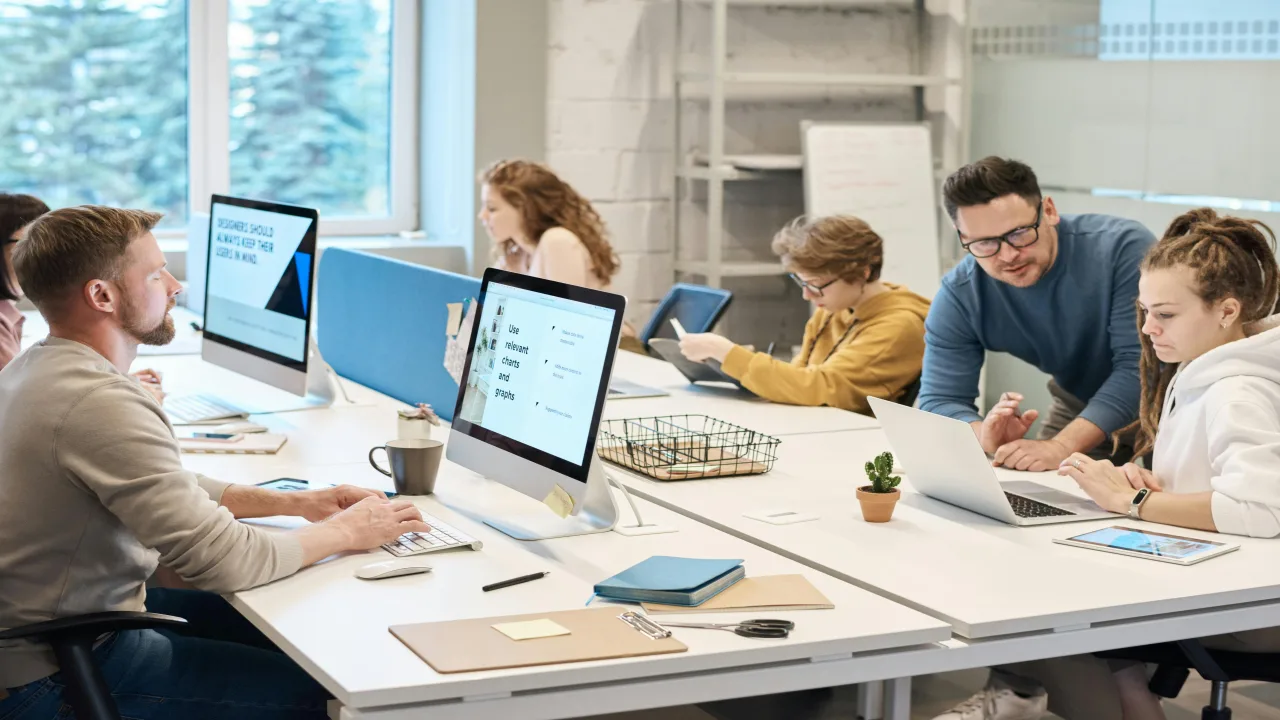 Deux collègues souriants qui échangent une bonne nouvelle au bureau, expression tant mieux